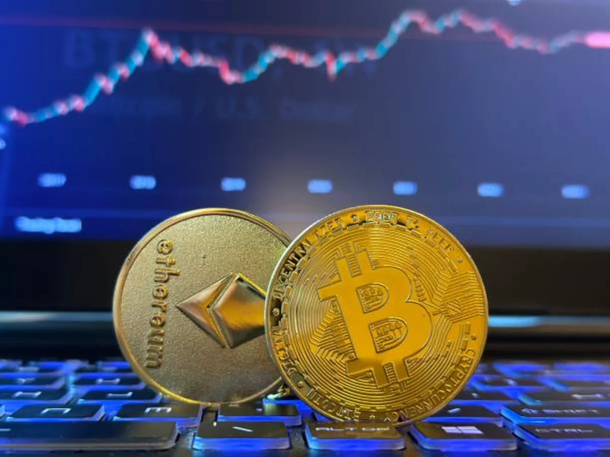 Physical gold Bitcoin and Ethereum coins rest together on a dark surface, illustrating the June 25 2026 ThriveInMarkets evening review crypto section as Bitcoin slid back below 60,000 dollars to about 59,245 at a roughly 20-month low and Ethereum eased to about 1,563 dollars, with digital assets tracking a second day of semiconductor and AI selloff in a broad risk-off move