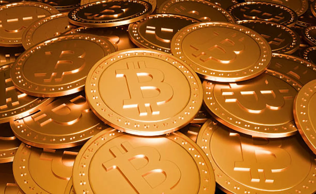 A pile of golden physical Bitcoin coins, illustrating the June 26 2026 ThriveInMarkets evening review crypto section as Bitcoin touched its lowest level since September 2024 near 58,189 dollars before recovering to about 59,632, Ethereum eased to around 1,569 dollars and roughly 1 billion dollars in leveraged futures positions were liquidated in a broad crypto selloff tracking the week's technology rout