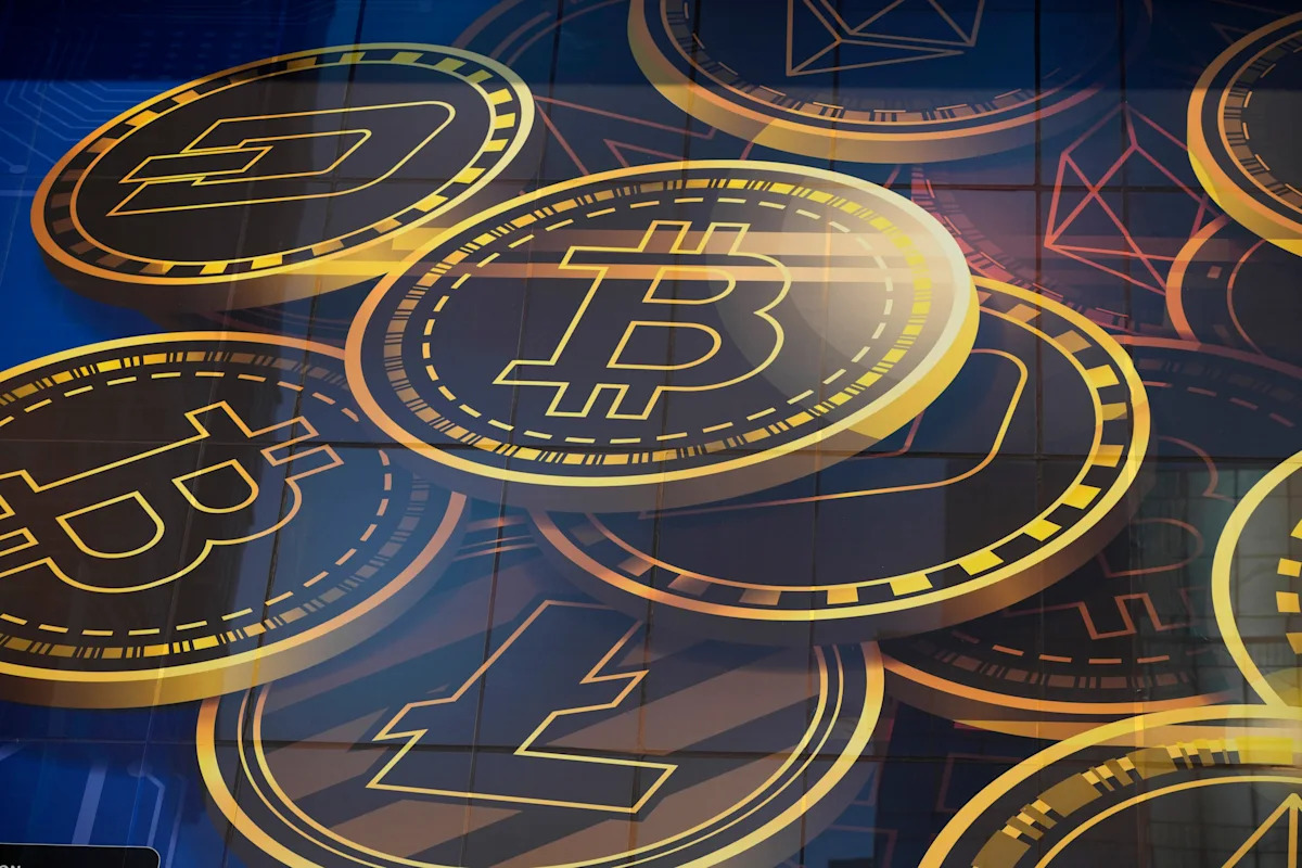 Gold-toned Bitcoin, Ethereum and Litecoin logos on a dark blue tiled wall, used as the ThriveInMarkets evening-review inline image for Tuesday September 15 2026, when Bitcoin last printed about 76,004 dollars after the Senate failed to invoke cloture on the Clarity Act and tagged a low near 74,910 dollars