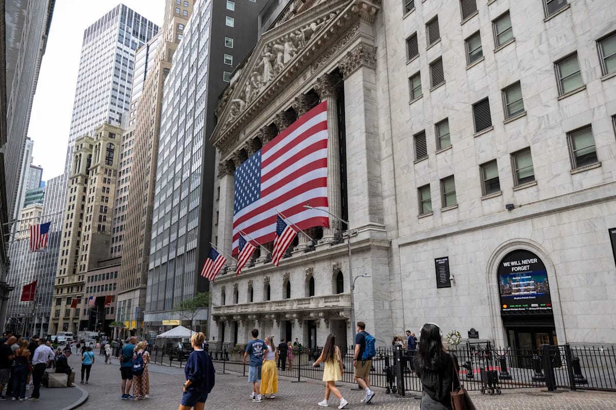 The New York Stock Exchange facade on Wall Street with a large American flag across the columns, used as the ThriveInMarkets evening-review hero for Wednesday September 30 2026, when the S&P 500 closed 7,651.54 at the session low after a 7,722.88 high as August core PCE rose 0.2 percent and the 10-year Treasury yield held near 5.30 percent