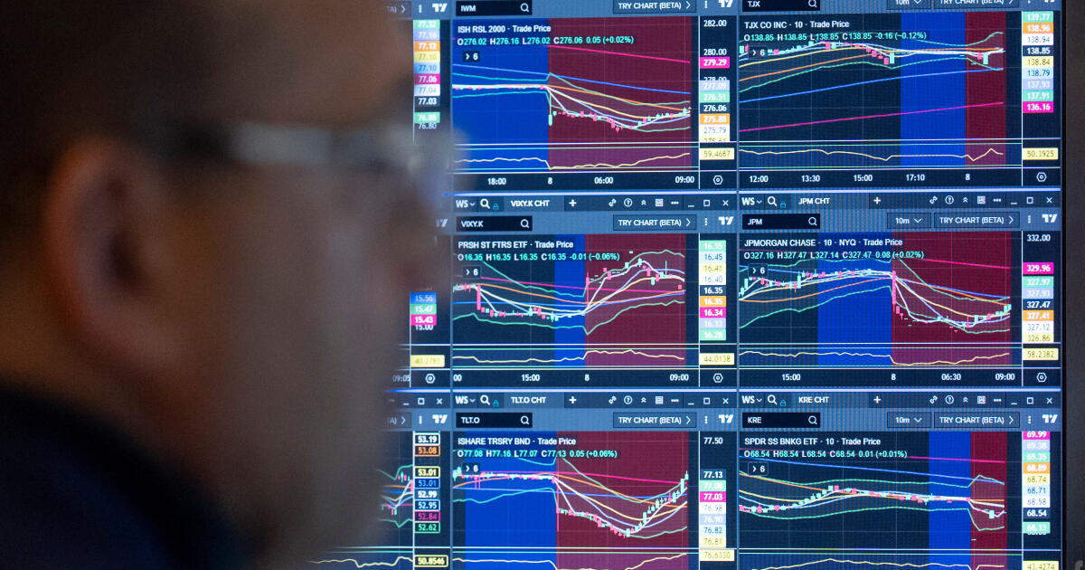 A trader looks at a bank of TradingView charts covering Russell 2000, Treasury and bank ETFs, used as the ThriveInMarkets evening-review hero for Friday October 9 2026, when the S&P 500 closed 7,811.54 just off Tuesday's 7,818.93 record and T-Mobile closed 148.02 dollars down 13.6 percent after SpaceX agreed to buy 800 MHz spectrum