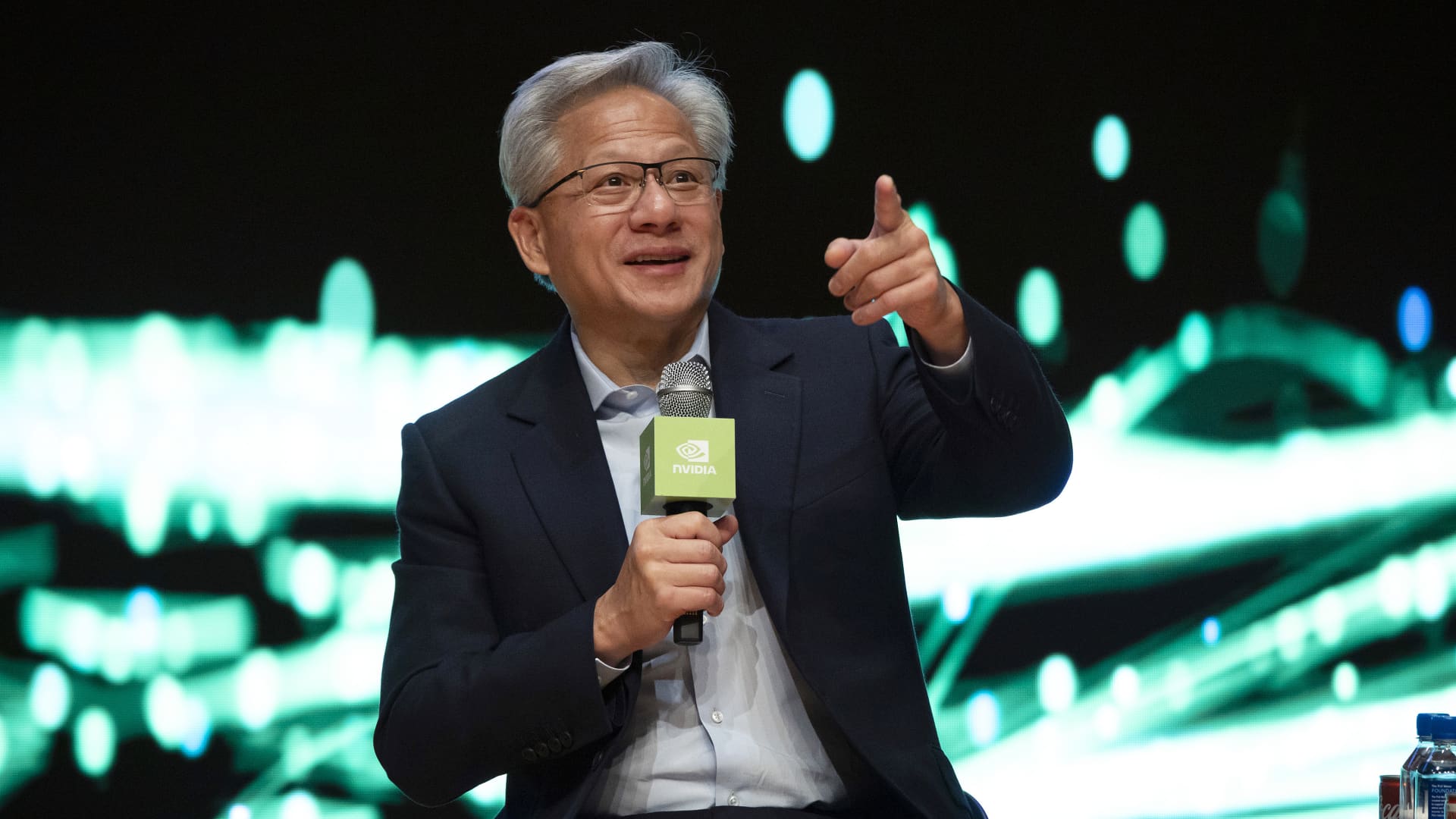 Photograph of Nvidia CEO Jensen Huang at an industry event illustrating the chipmaker's fiscal Q1 2027 earnings print on Wednesday May 20 2026 after the US market close, the single biggest single-stock catalyst of the second quarter, where Nvidia delivered revenue of 81.6 billion dollars beating the 79.2 billion dollar Street consensus with 1.87 dollars EPS versus 1.77 dollars expected, data center revenue of 75.2 billion dollars up 92 percent year-over-year, a Q2 guide of 89.1 to 92.8 billion dollars versus 87.3 billion dollars consensus, an 80 billion dollar share buyback authorization and a 25-fold quarterly dividend hike from 1 cent to 25 cents, yet the stock initially fell more than 2 percent in after-hours trading as expectations were sky-high heading into the print, the centerpiece of the ThriveInMarkets Thursday May 21 2026 morning analysis covering also the April FOMC minutes showing four dissents the highest count since October 1992, the S&P 500 closing at a 7,432.97 record up 1.08 percent on the pre-Nvidia rally, WTI crude diving 5.66 percent to 98.26 dollars on Iran de-escalation, Bitcoin holding 77,564 dollars and Ethereum at 2,132 dollars