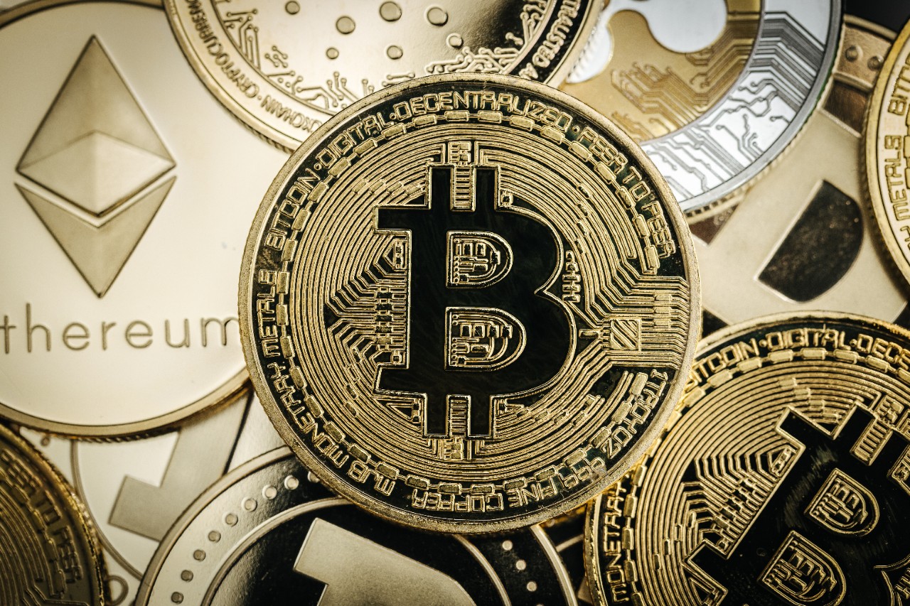 Physical Bitcoin coin set against a glowing price chart illustrating the June 3 2026 ThriveInMarkets morning analysis as Bitcoin slid to a five-week low under 67,000 dollars, dropping about 5 percent over 24 hours after US spot bitcoin exchange-traded funds logged their longest run of net redemptions on record and a fresh US-Iran military escalation triggered roughly 1.6 billion dollars in leveraged long liquidations, even as a Marvell-led chip boom carried the S&P 500 to another record close above 7,600 while gold eased toward 4,466 dollars and WTI crude held firm near 94 dollars