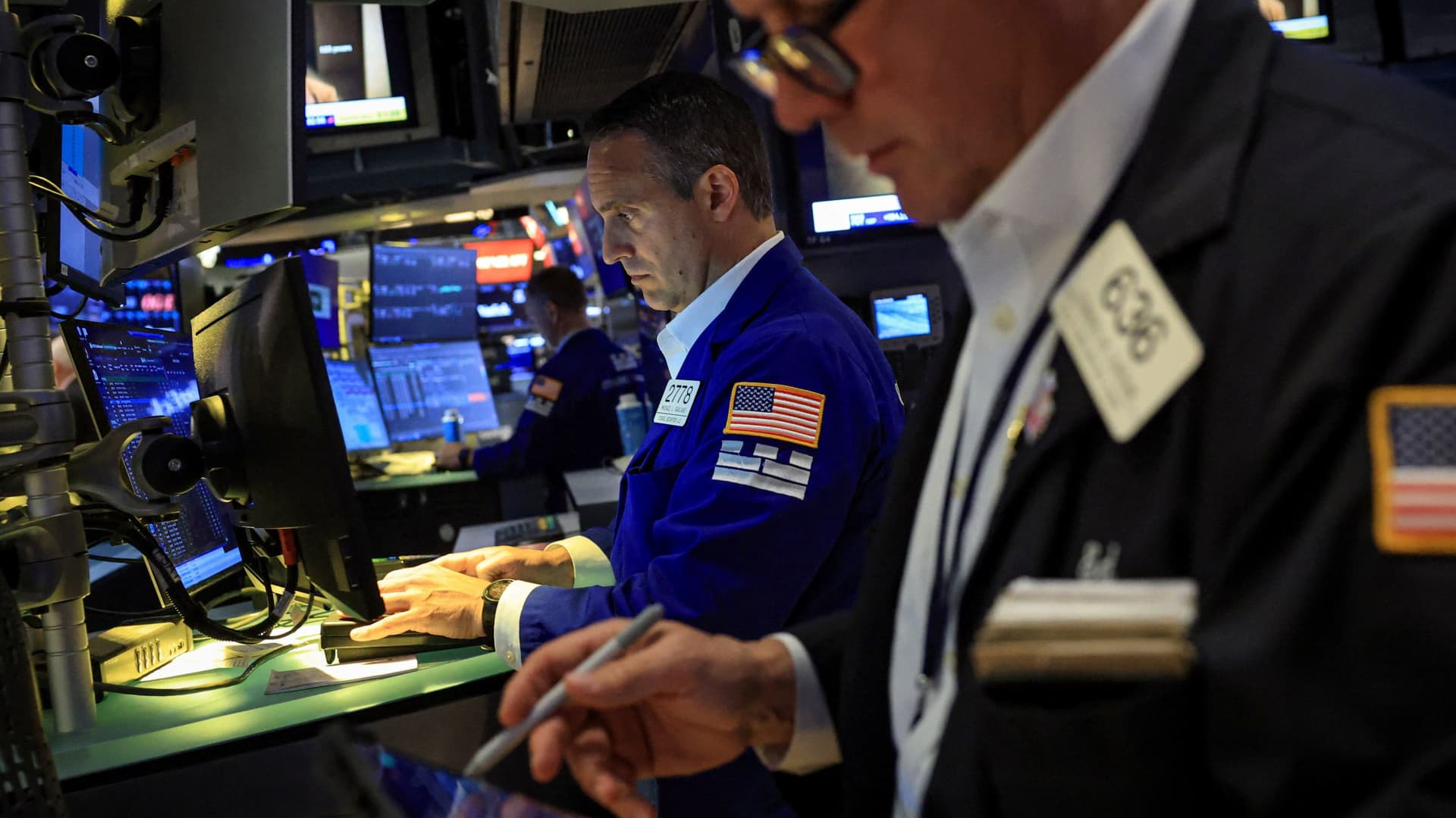 Traders work the floor of the New York Stock Exchange beneath glowing screens, illustrating the June 23 2026 ThriveInMarkets morning analysis as a US-Iran peace roadmap mediated by Qatar and Pakistan aims for a final deal within 60 days, sending WTI crude toward 74 dollars after the US Treasury authorized the sale of Iranian oil for 60 days, lifting S&P 500 E-mini futures nearly 1 percent toward 7,545 against a Monday June 22 cash close of 7,472.79, while Bitcoin held near 63,900 dollars roughly flat over 24 hours, Ethereum jumped about 2.7 percent toward 1,690 dollars to outpace the majors, and spot gold steadied near 4,117 dollars as the easing geopolitical risk premium trimmed safe-haven demand
