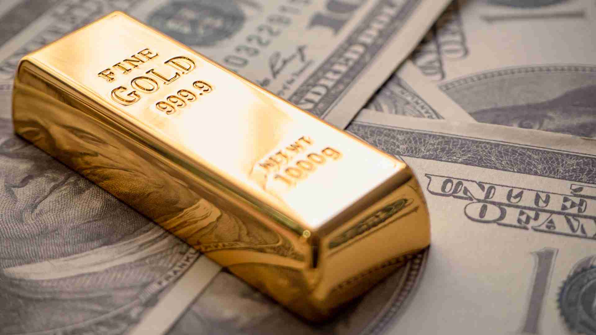 A cluster of polished gold bars and coins on a dark reflective surface under warm amber light, symbolising gold holding above 4,254 dollars on Friday August 7 2026 and tracking its most profitable weekly close since January, up about 5 percent on the week ahead of the US July non-farm payrolls report as falling oil earlier in the week, a softer dollar and easing Treasury yields lifted the metal