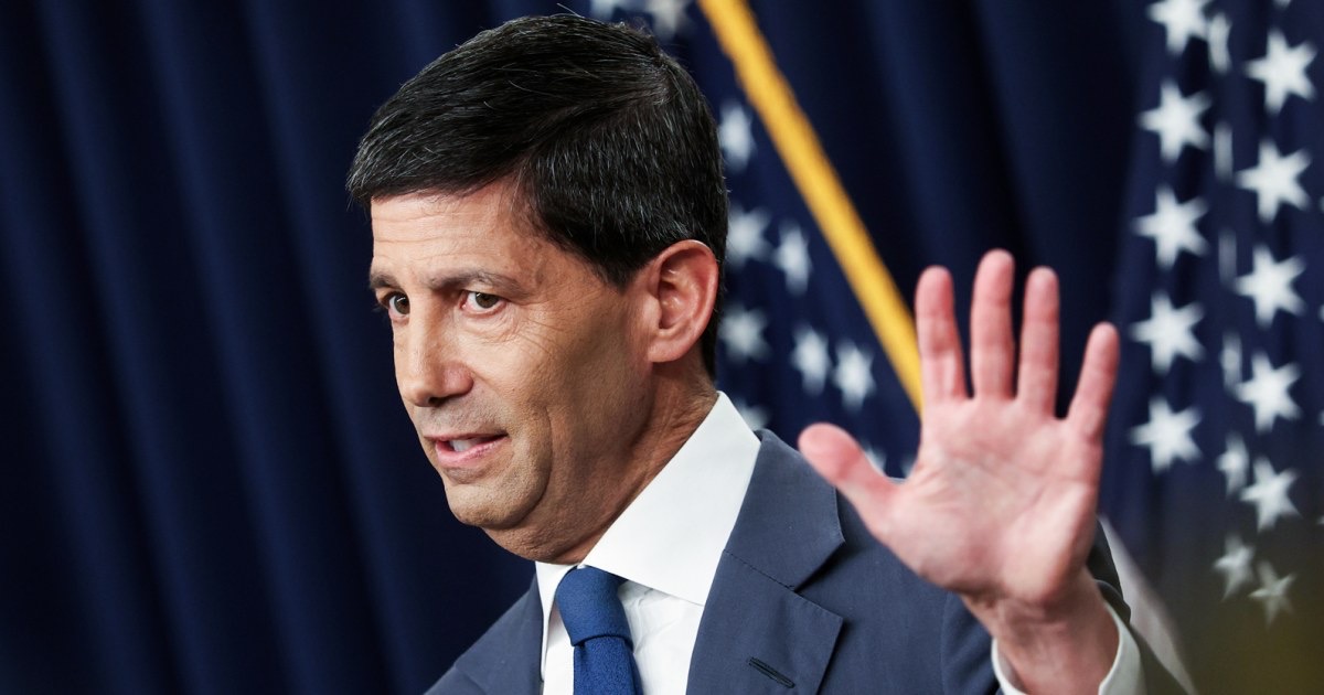 Federal Reserve Chair Kevin Warsh speaking with his right hand raised in front of a US flag and navy curtain, used as the ThriveInMarkets morning analysis hero for Friday August 28 2026, when Warsh delivers his first Jackson Hole keynote at 14:00 UTC after a thin Nvidia-led S&P close of 7,730.99 and overnight E-mini futures near 7,744