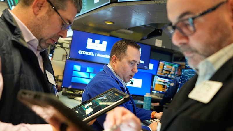 NYSE floor traders in blue jackets work tablets and Citadel Securities screens, used as the ThriveInMarkets morning analysis inline image for Monday August 31 2026, when overnight E-mini S&P 500 futures held near 7,710 against Friday's 7,711.76 cash close as Chair Kevin Warsh's Jackson Hole keynote kept September hike odds near 62 percent and US cash reopened into German flash CPI and a payrolls-week docket