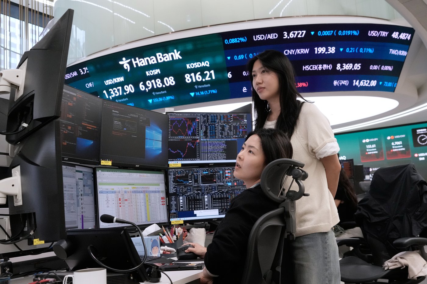 Two traders watch a curved Hana Bank board showing KOSPI, KOSDAQ and dollar crosses above a bank of chart screens in Seoul, used as the ThriveInMarkets morning analysis inline image for Thursday September 10 2026, when Asian equity benchmarks slid as Brent crude held above 100 dollars after a 101.94 dollar high, overnight E-mini S&P 500 futures sat near 7,663 against Wednesday's 7,636.46 cash close, and markets waited on the ECB decision and US producer prices