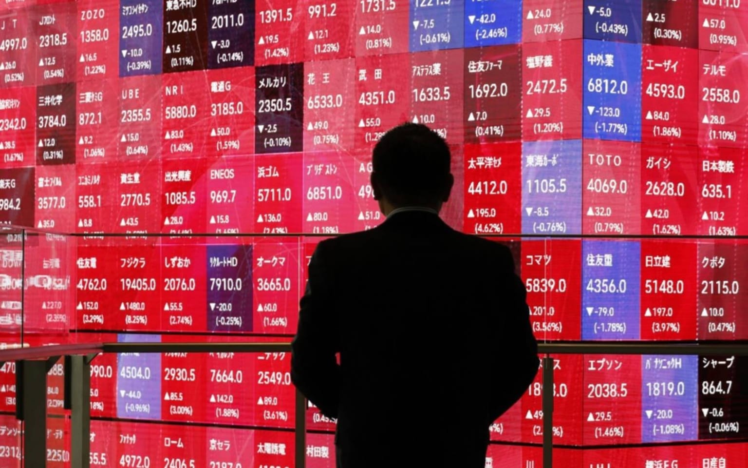 A man in a dark suit stands silhouetted before a red and blue Tokyo stock-indicator board, used as the ThriveInMarkets morning analysis inline image for Thursday September 24 2026, when Japan's Nikkei 225 reopened about 1 percent higher after a three-day holiday, semiconductor names including Ibiden led after Meta unveiled its Charm gadget, and the Japanese 10-year yield tagged 3.055 percent, a three-decade high