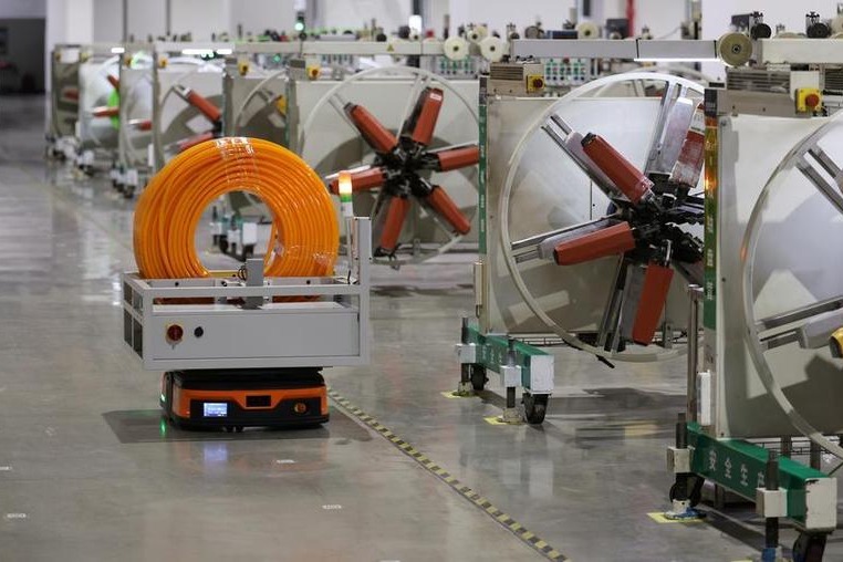An automated guided vehicle carries a coil of orange cable through a building-materials workshop in Tianjin on 28 August 2026, used as the ThriveInMarkets morning analysis inline image for Wednesday September 30 2026, when China's official manufacturing PMI printed 50.1, ending two months of contraction, with production at 51.7 and high-tech manufacturing at 52.5