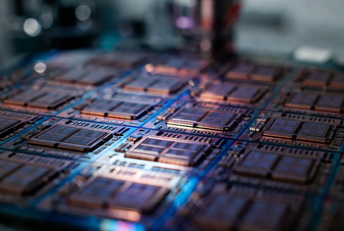 Macro close-up of advanced silicon chip wafer with copper interconnects under fab lighting representing TSMC AI supercycle Tesla AI5 Nvidia capex