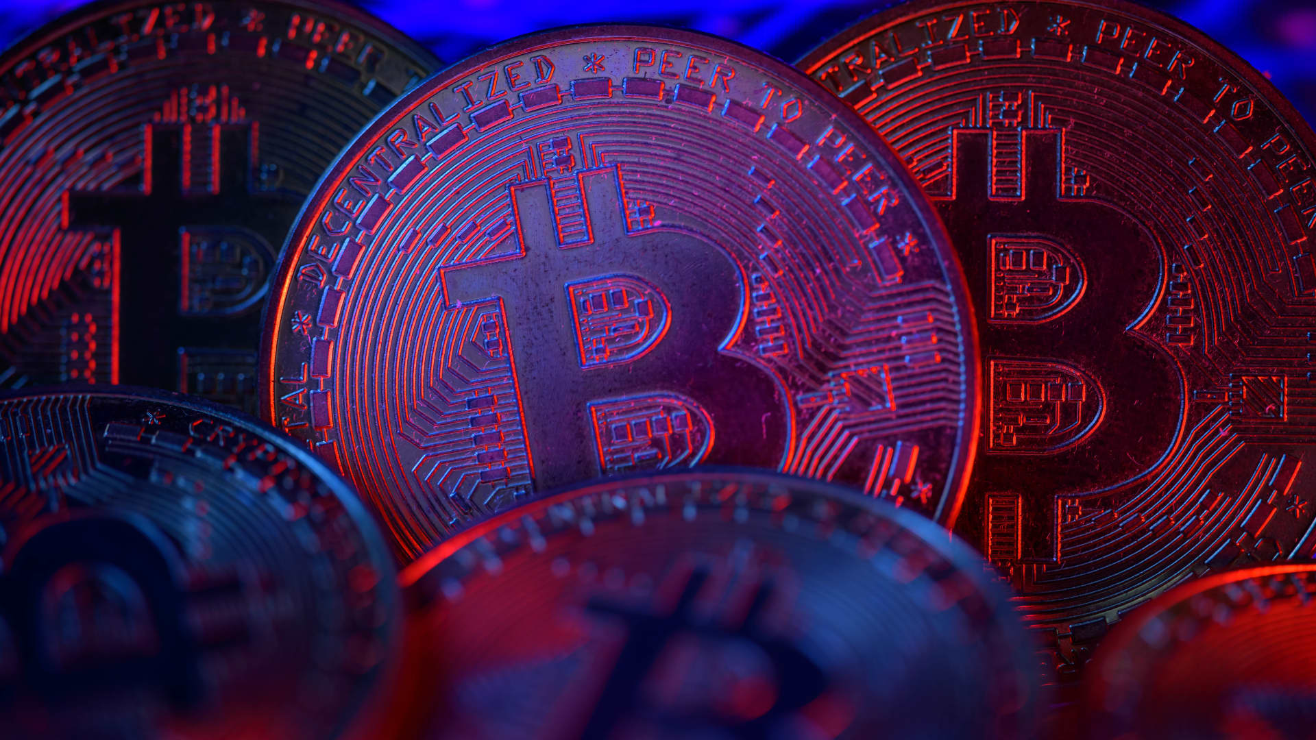 A physical Bitcoin token set against a falling price chart illustrating crypto's worst week since the 2022 FTX collapse, as Bitcoin slid toward the 60,000 dollar psychological level last seen in February 2026 and US spot exchange-traded funds ended a record 13-day outflow streak of roughly 4.33 billion dollars while nearly 7 billion dollars in leveraged positions were liquidated across the market